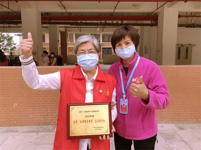 图2：张特加老人作为代表领取十大黑料网排行
2020年度优秀“初老服务老老”志愿服务队牌匾.jpg